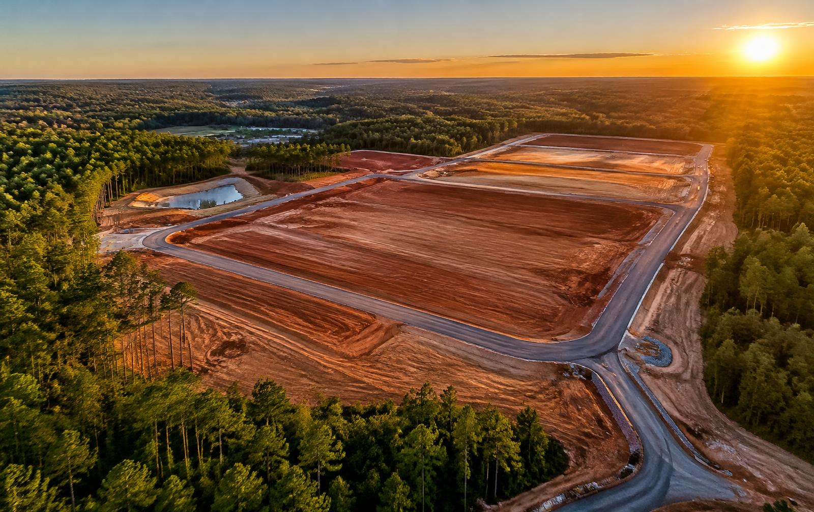 Aerial view of large-scale land development with graded pads and new roads